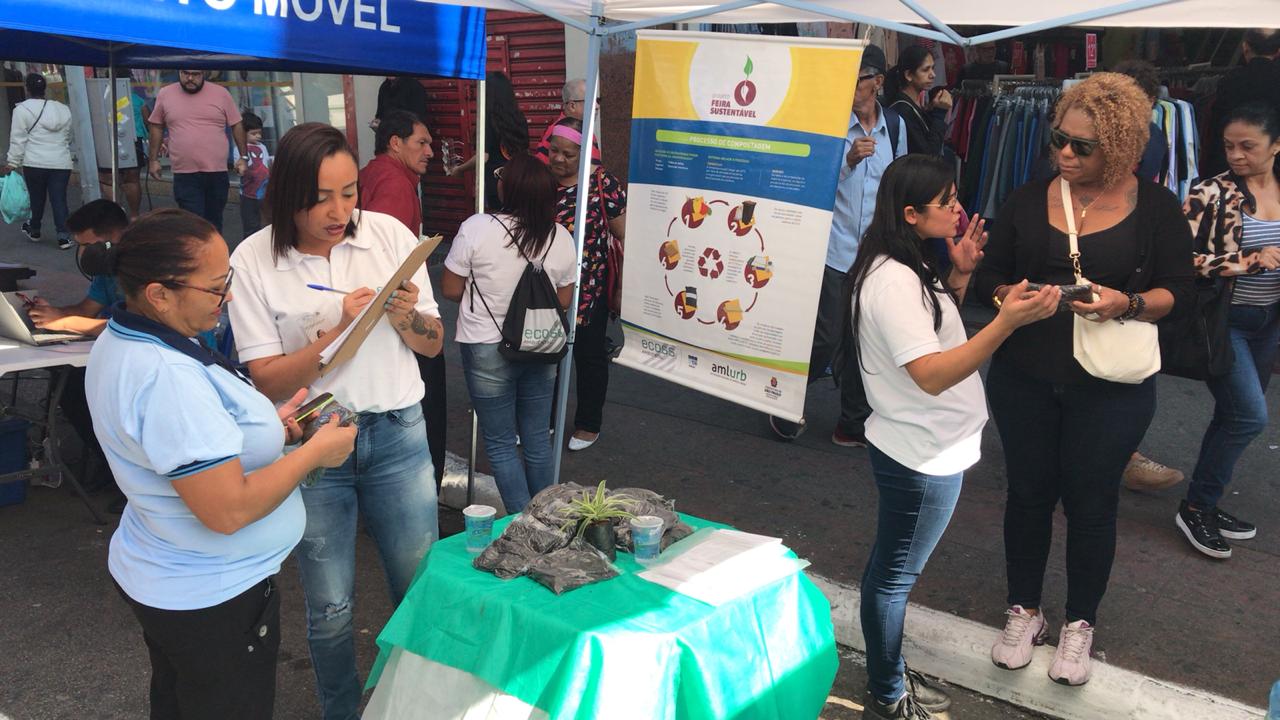 Destaque para duas duplas de mulheres durante orientação e distribuição de composto 